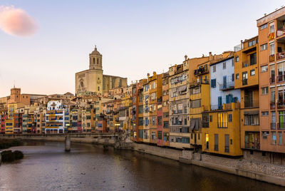 View of buildings by river against clear sky