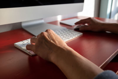 Midsection of man using laptop on table