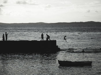Young people jumping from the pier of porto da barra