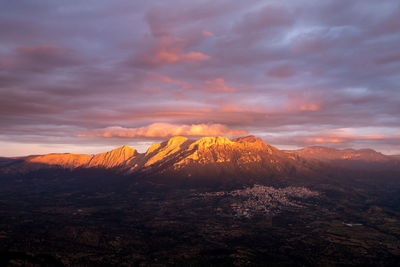 View of landscape against cloudy sky during sunset