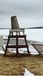 Lifeguard hut on beach against sky