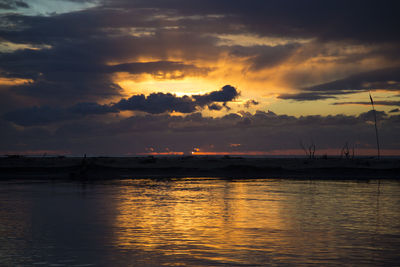 Scenic view of sea against cloudy sky during sunset