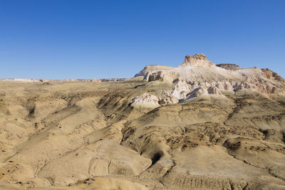 Rock formations in desert against clear blue sky