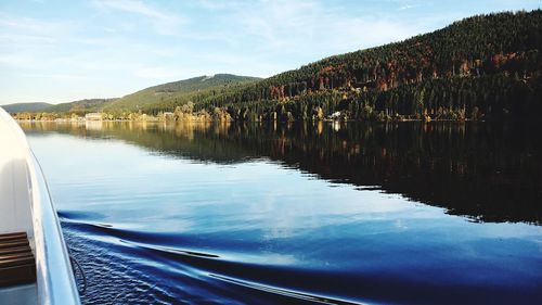 Scenic view of lake by mountains against sky