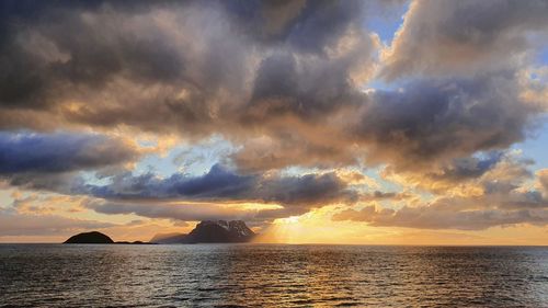 Scenic view of sea against dramatic sky during sunset