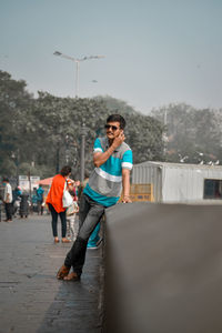 Young guy standing in city against sky