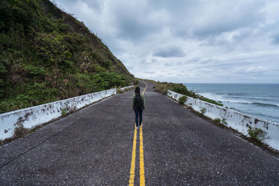 Rear view of man on road against sky