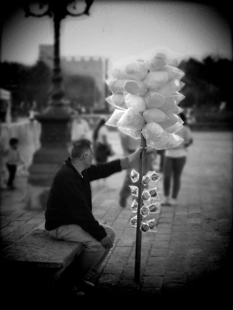 one person, holding, real people, focus on foreground, flower, flowering plant, lifestyles, nature, leisure activity, day, full length, outdoors, men, plant, fragility, freshness, selective focus, sitting, vulnerability