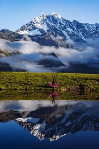 Full length of man walking on snowcapped mountains against sky