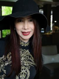 Close-up portrait of smiling young woman with hat