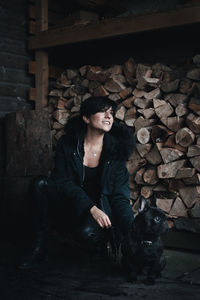 Portrait of young man sitting on log