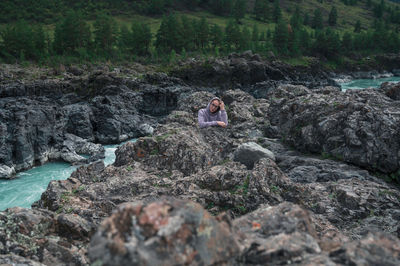 High angle view of man sitting on rock