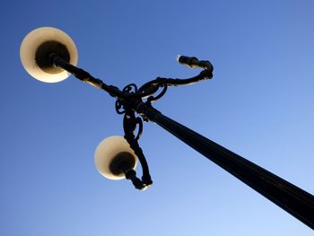 Low angle view of hanging against clear blue sky
