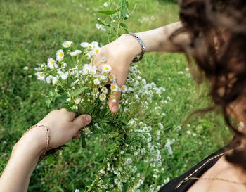 Low section of woman holding flowers