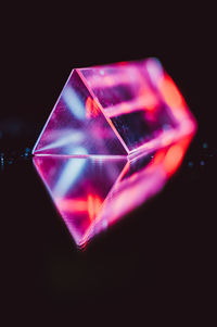 Close-up of illuminated lighting equipment against black background