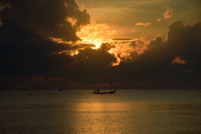 Silhouette boat sailing on sea against sky during sunset