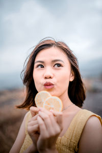 Close-up of woman holding orange slices