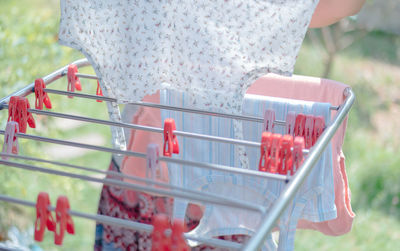 Cropped image of woman picking clothes from laundry rack