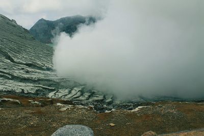 Smoke emitting from volcanic mountain against sky