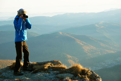 Full length of woman standing on mountain against sky