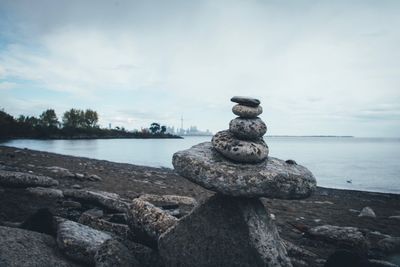 Stack of stones on beach against sky