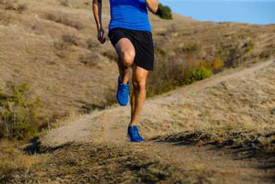 Male athlete running on mountain trail