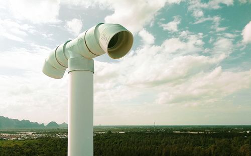 Smoke stack on land against sky