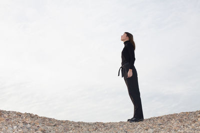 Full length of woman standing on beach against sky