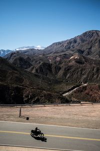 View of people riding motorcycle on mountain road