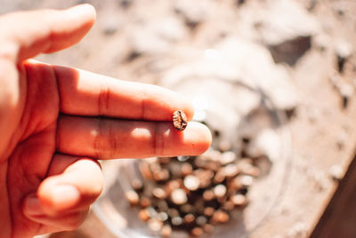 Close-up of woman hand holding cigarette against blurred background