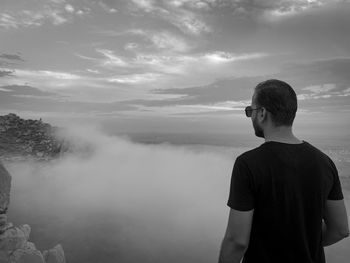 Rear view of man standing against sky