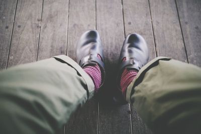 Low section of man standing on wood