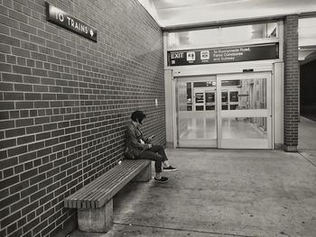 Full length of against a wall at bus depot