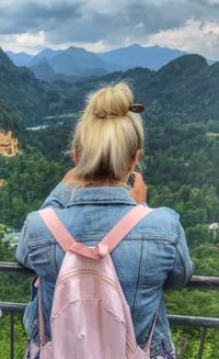 Rear view of woman standing against mountains