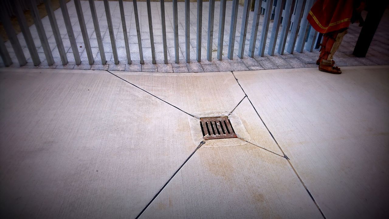 LOW SECTION OF PERSON WITH UMBRELLA ON FLOOR