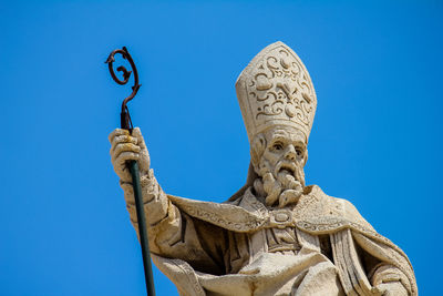 Low angle view of statue against blue sky