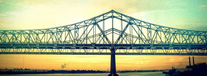 Bridge over river against cloudy sky