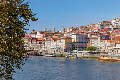 Buildings by sea against sky