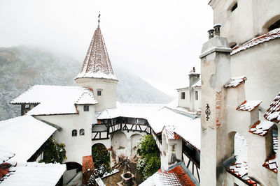 Snow covered bran castle by mountain at transylvania