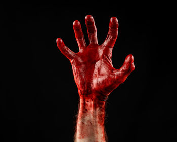 Close-up of human hand against black background