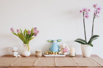 Decorations on table by white wall