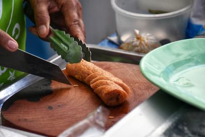 Cropped hand of person preparing snacks on table