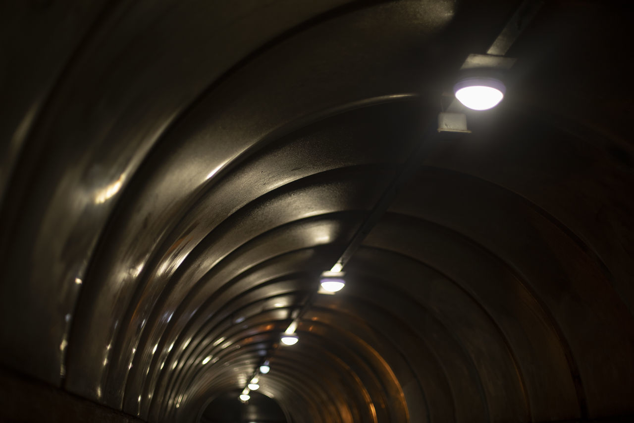 tunnel, indoors, light, architecture, illuminated, darkness, lighting equipment, no people, infrastructure, ceiling, built structure, arch, diminishing perspective, low angle view, light - natural phenomenon, subway