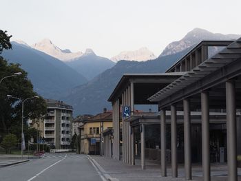 Road leading towards mountains against clear sky