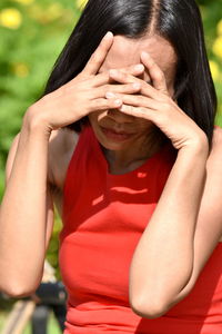 Close-up of woman covering face with hands