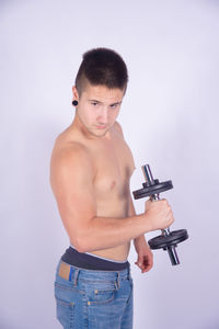 Full length of shirtless man standing against white background