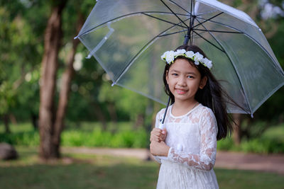 Portrait of a smiling girl standing in rain