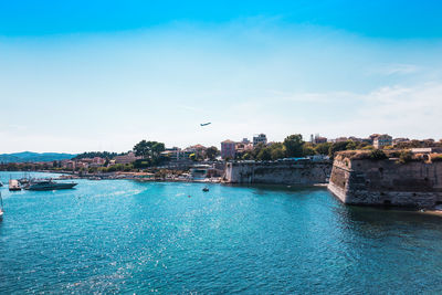 Scenic view of sea by buildings against sky