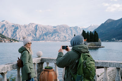 Rear view of man standing by lake