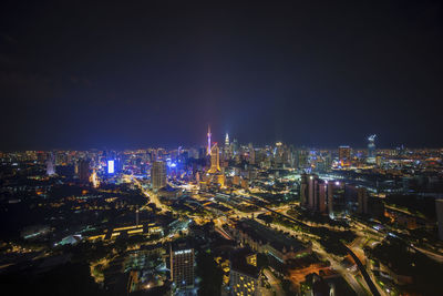 Illuminated cityscape against sky at night